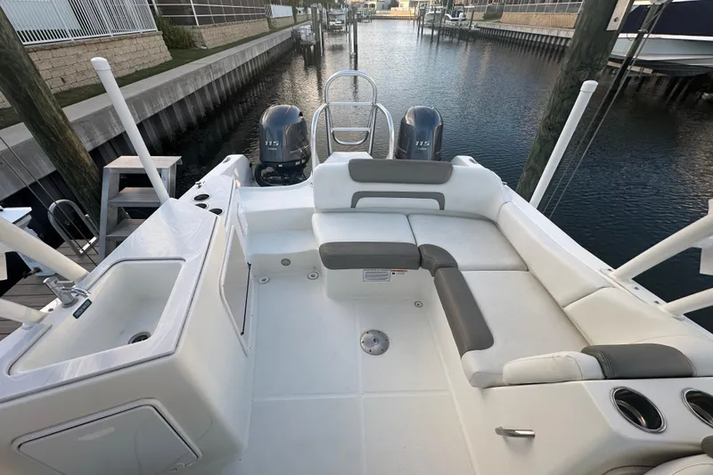 Slide: The Image of 2021 World Cat 230 SD boat interior with seating and dual engines in a marina setting. - 59