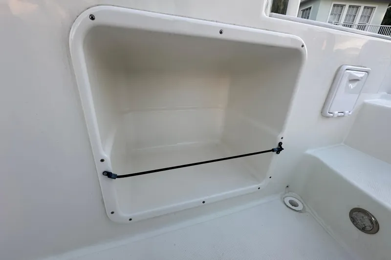 Slide: The Image of Storage compartment on 2021 World Cat 230 SD boat, featuring a secure bungee cord. - 89