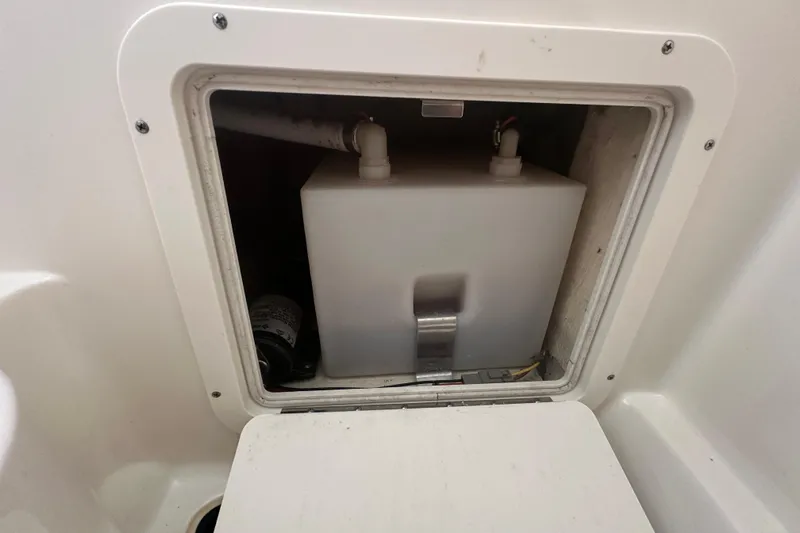 Slide: The Image of 2021 World Cat 230 SD storage compartment with a white tank and plumbing connections. - 74