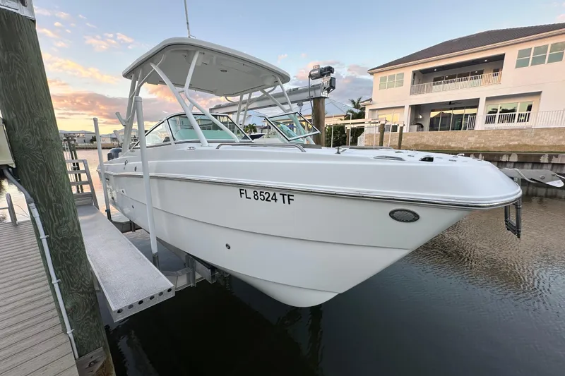 Slide: The Image of 2021 World Cat 230 SD boat docked at marina, sunset view, waterfront property. - 1