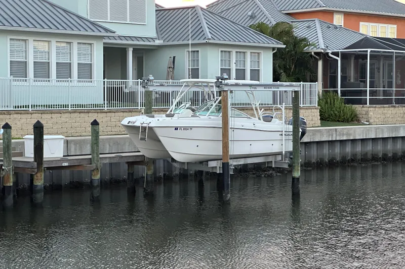 Slide: The Image of 2021 World Cat 230 SD boat docked at waterfront home with lift system. - 115