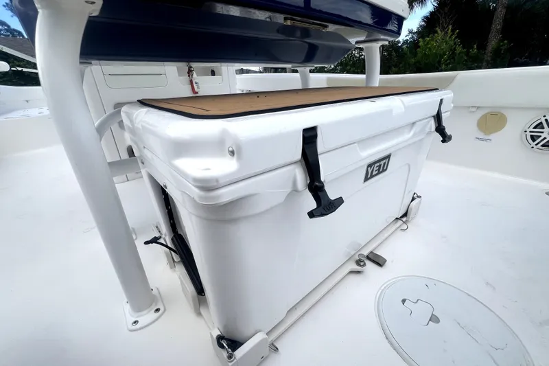 Slide: The Image of YETI cooler on 2020 Caymas 26 HB boat deck, featuring secure latches and white finish. - 75