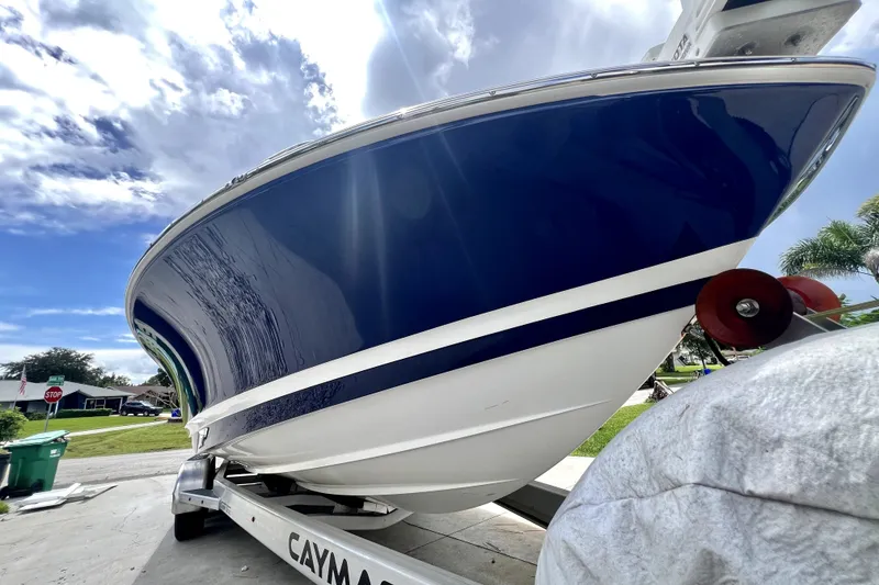 Slide: The Image of 2020 Caymas 26 HB boat on trailer under a partly cloudy sky. - 9