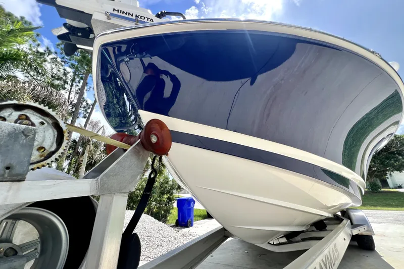 Slide: The Image of 2020 Caymas 26 HB boat on trailer, featuring sleek blue hull and Minn Kota motor. - 8