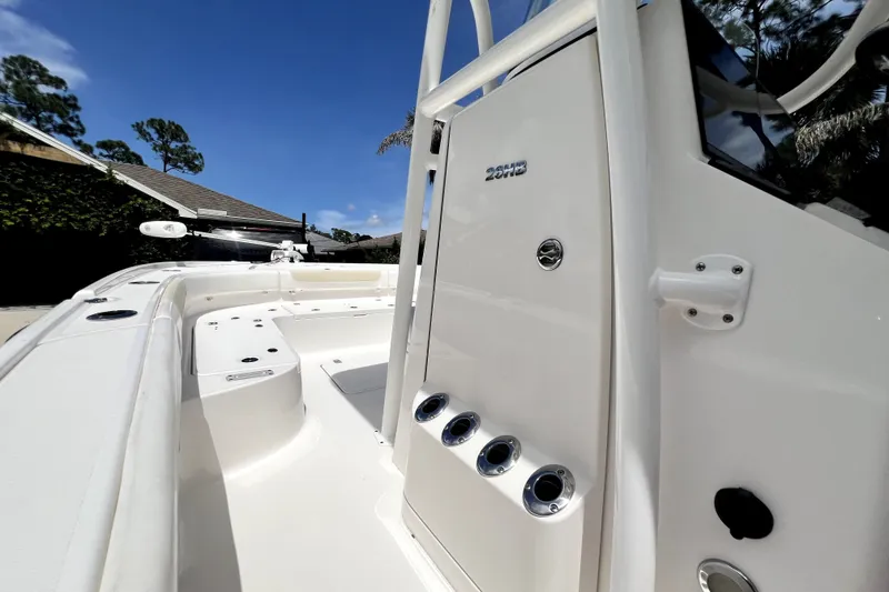 Slide: The Image of 2020 Caymas 26 HB boat deck with rod holders under clear blue sky. - 65