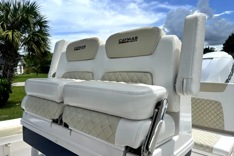 Slide: The Image of 2020 Caymas 26 HB boat seating with white cushioned upholstery and palm tree background. - 92