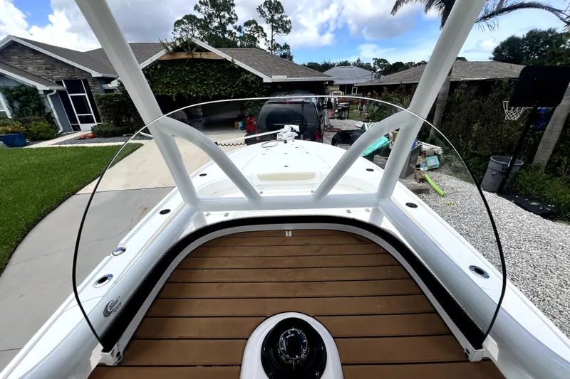 Slide: The Image of 2020 Caymas 26 HB boat with wooden deck, parked in a residential driveway. - 23