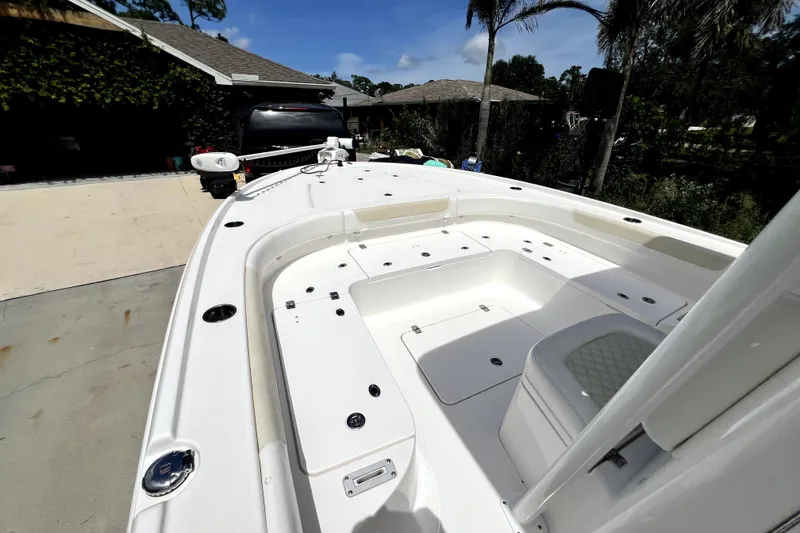 Slide: The Image of 2020 Caymas 26 HB boat with spacious deck and seating, parked outdoors. - 76