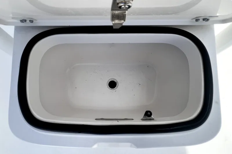 Slide: The Image of Open storage compartment on 2020 Caymas 26 HB boat, featuring a drain hole. - 43