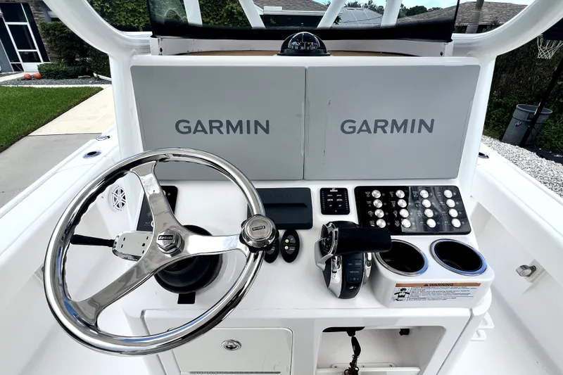 Slide: The Image of 2020 Caymas 26 HB boat dashboard with Garmin displays and steering wheel. - 32