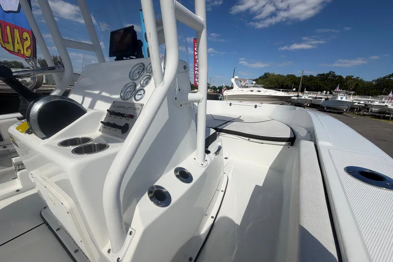 Slide: The Image of 2020 Clearwater 2000 Center Console boat with control panel and cup holders, docked under blue sky. - 45