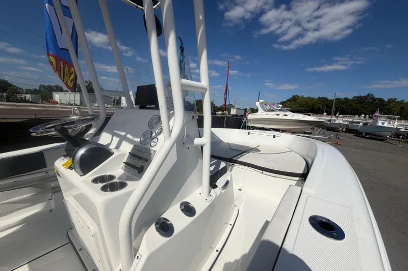 Slide: The Image of 2020 Clearwater 2000 Center Console boat with steering console, gauges, and cup holders under a clear sky. - 44