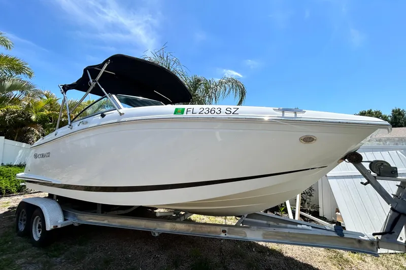 The Image of 2020 Cobalt 23SC boat on trailer, sunny day, palm trees in background. - 0