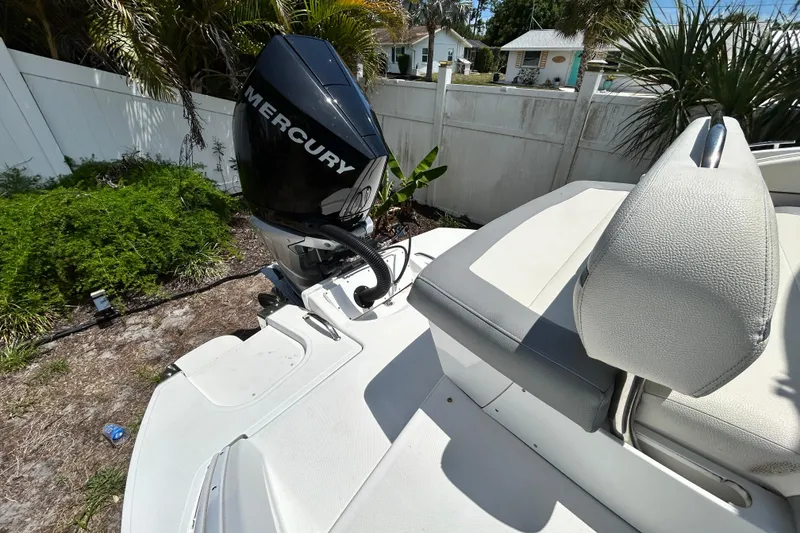 Slide: The Image of 2020 Cobalt 23SC boat with Mercury outboard motor, parked in a garden setting. - 96