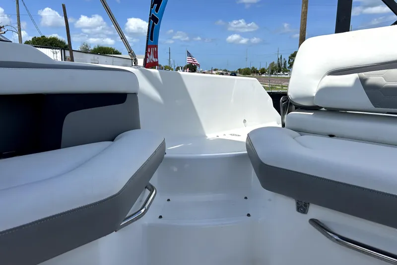 Slide: The Image of 2020 Four Winns HD220 boat interior with white and gray seating, under a clear blue sky. - 53
