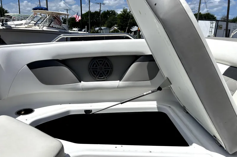 Slide: The Image of Open storage compartment on 2020 Four Winns HD220 boat, featuring cushioned seating and speaker. - 41