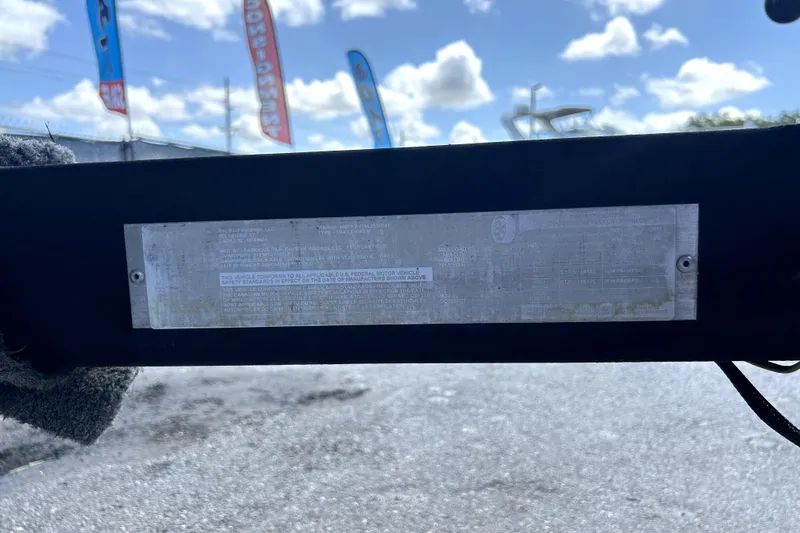 Slide: The Image of 2020 Four Winns HD220 boat identification plate with sky and flags in background. - 70