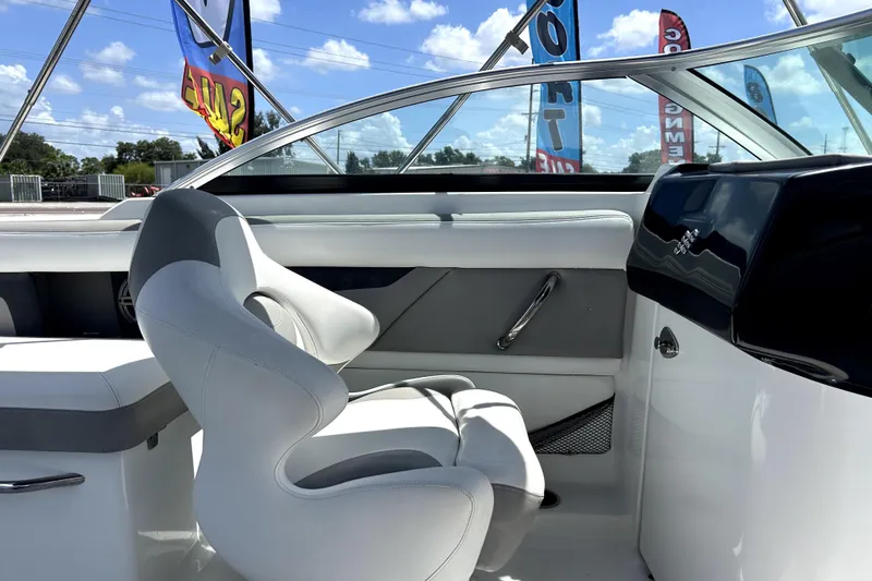 Slide: The Image of 2020 Four Winns HD220 boat interior with sleek seating and dashboard under sunny skies. - 29