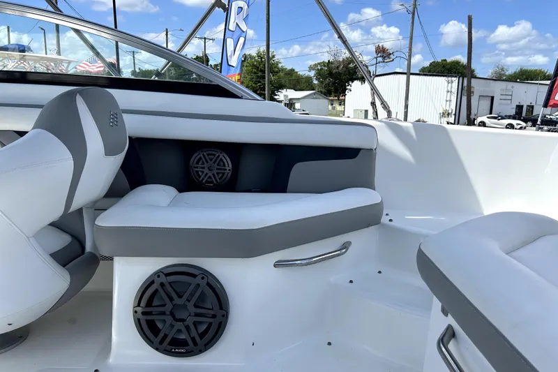 Slide: The Image of 2020 Four Winns HD220 boat interior with white and gray seating, visible speakers. - 54