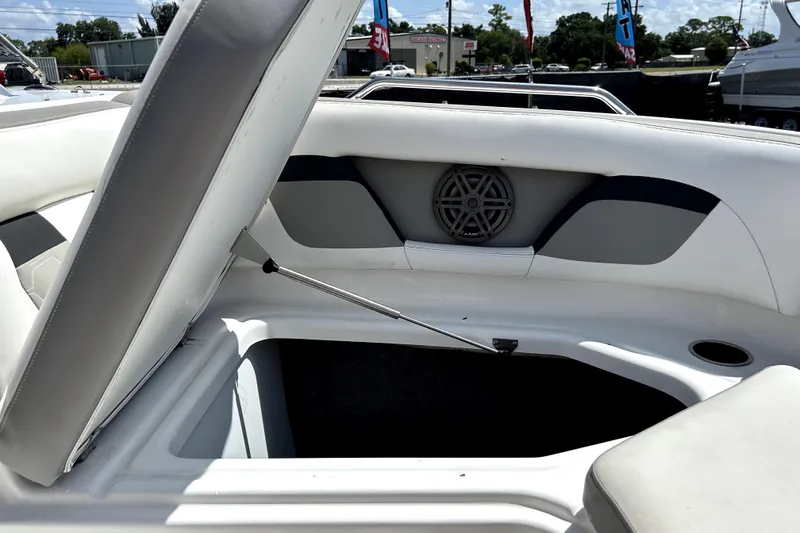 Slide: The Image of 2020 Four Winns HD220 boat interior with open storage compartment and speaker. - 38