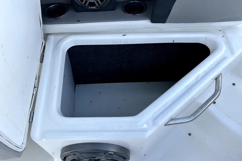 Slide: The Image of Storage compartment in a 2020 Four Winns HD220 boat, featuring a speaker and cup holder. - 56