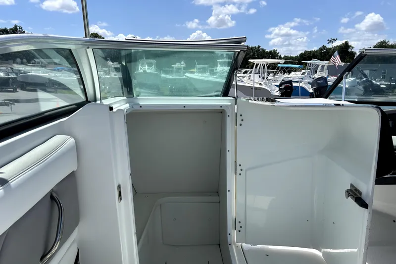 Slide: The Image of 2020 Four Winns HD220 boat interior with open storage compartment under sunny skies. - 31