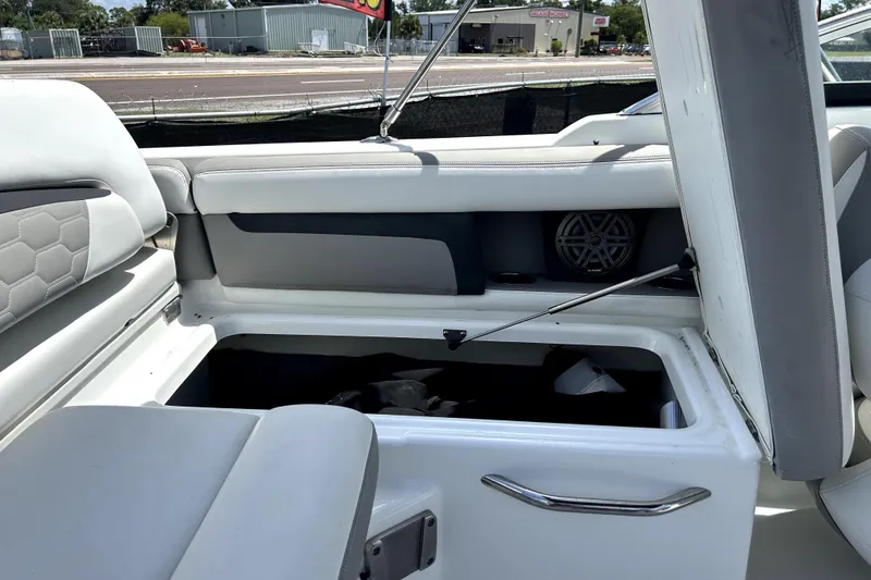 Slide: The Image of 2020 Four Winns HD220 boat interior with open storage compartment and speaker. - 51