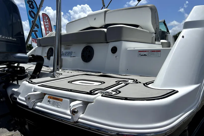 Slide: The Image of 2020 Four Winns HD220 boat rear view with seating and motor details. - 62