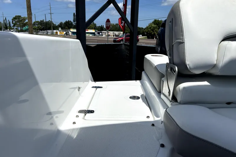 Slide: The Image of 2020 Four Winns HD220 boat interior with white seating and storage compartment. - 57