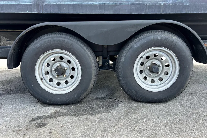 Slide: The Image of Dual wheels on a 2020 Four Winns HD220 boat trailer, parked on asphalt. - 72