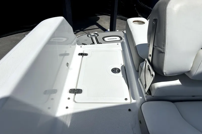 Slide: The Image of 2020 Four Winns HD220 boat interior with white seating and storage compartment. - 58