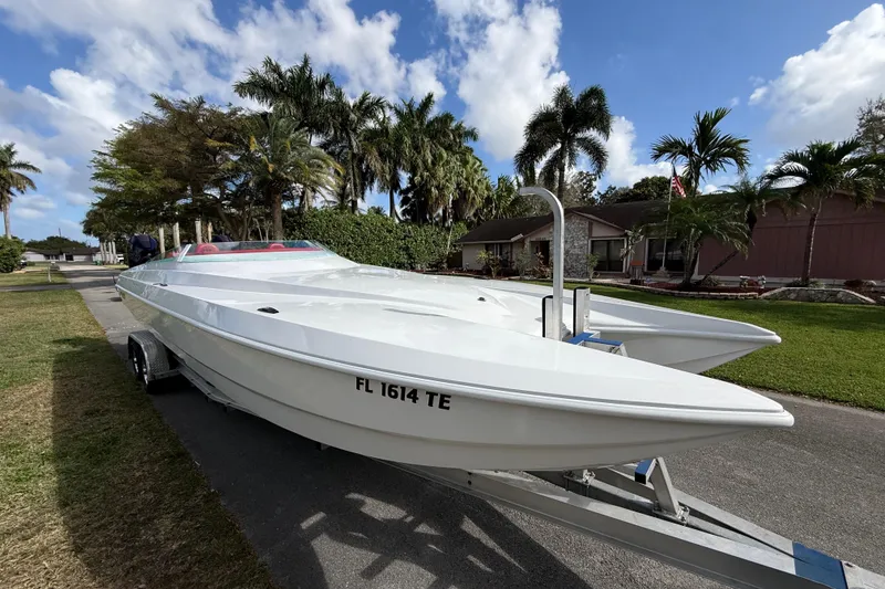 Slide: The Image of 2020 HellKats 30 powerboat on trailer, parked in a tropical residential area. - 6