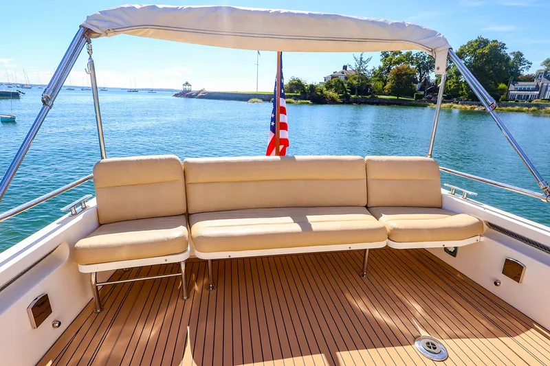 Slide: The Image of 2017 MJM 40z Downeast yacht with beige seating and American flag on deck. - 14