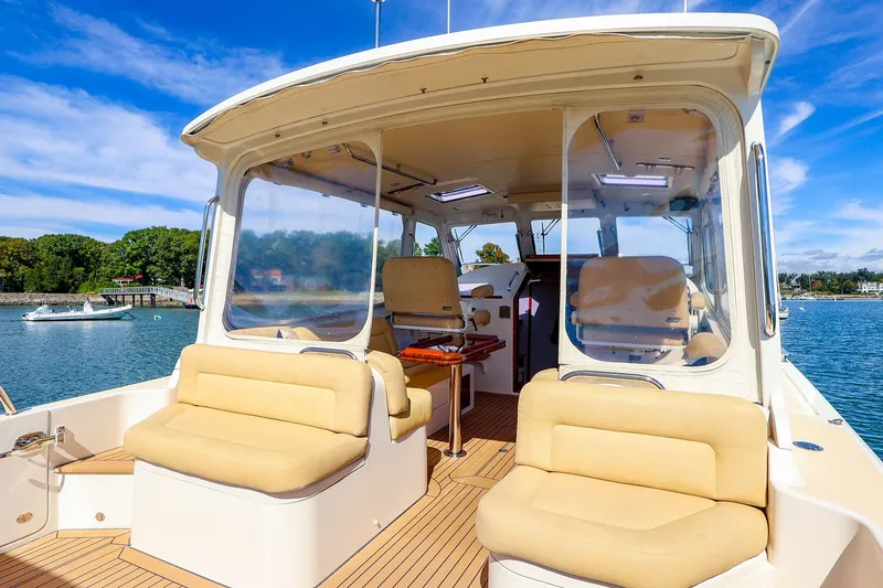 Slide: The Image of 2017 MJM 40z Downeast boat interior with beige seating and scenic water view. - 15