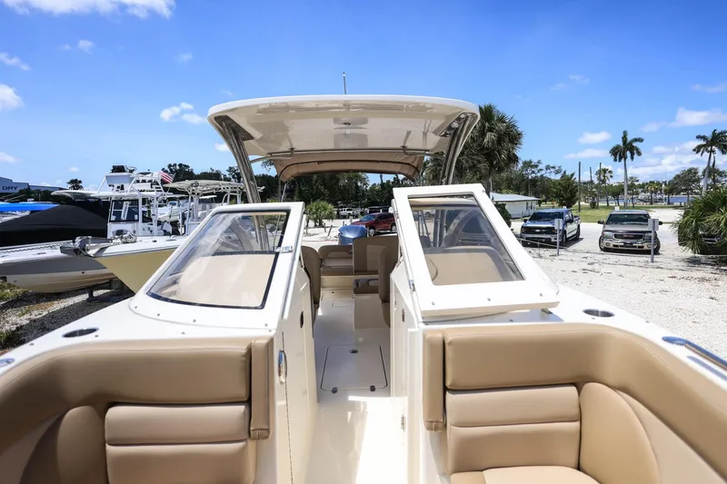 Slide: The Image of 2020 Scout 235 Dorado boat with tan seating and open deck, parked outdoors. - 29