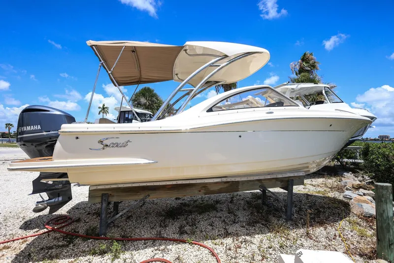 Slide: The Image of 2020 Scout 235 Dorado boat with Yamaha engine, parked on gravel under a clear blue sky. - 5