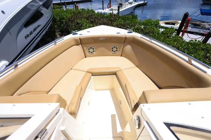 Slide: The Image of 2020 Scout 235 Dorado boat interior with tan seating, docked near water. - 26