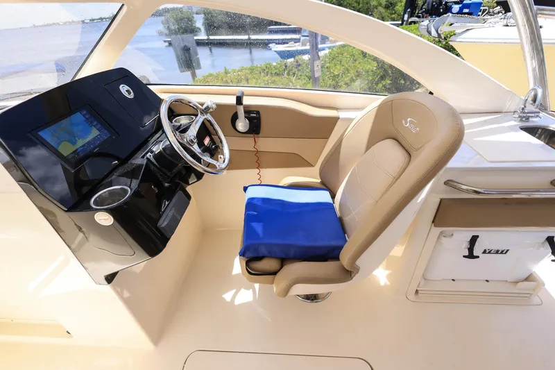 Slide: The Image of 2020 Scout 235 Dorado helm with steering wheel, navigation screen, and cushioned seat. - 21