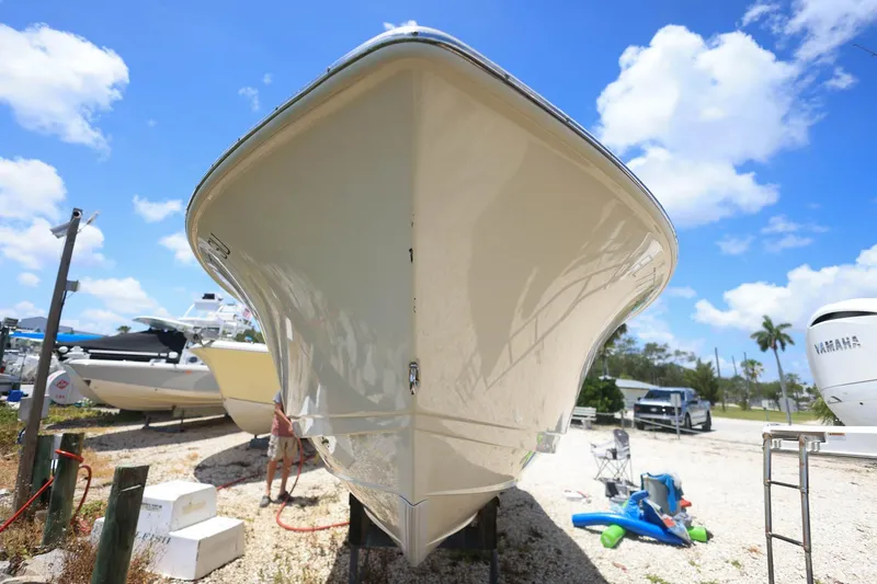 Slide: The Image of 2020 Scout 235 Dorado boat on dry land under a clear blue sky. - 4