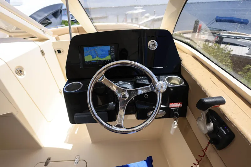 Slide: The Image of Le cockpit d'un bateau Scout 235 Dorado avec volant et écran de navigation. - 23