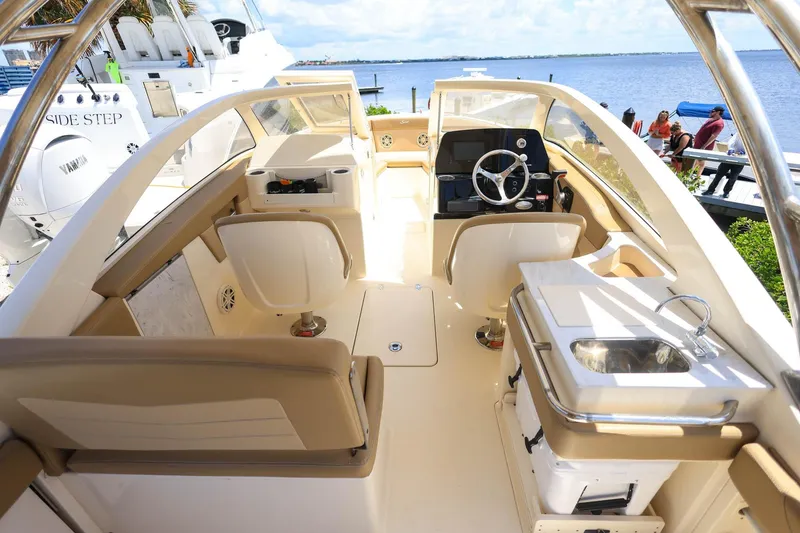 Slide: The Image of Interior view of a 2020 Scout 235 Dorado boat with seating and steering wheel. - 15