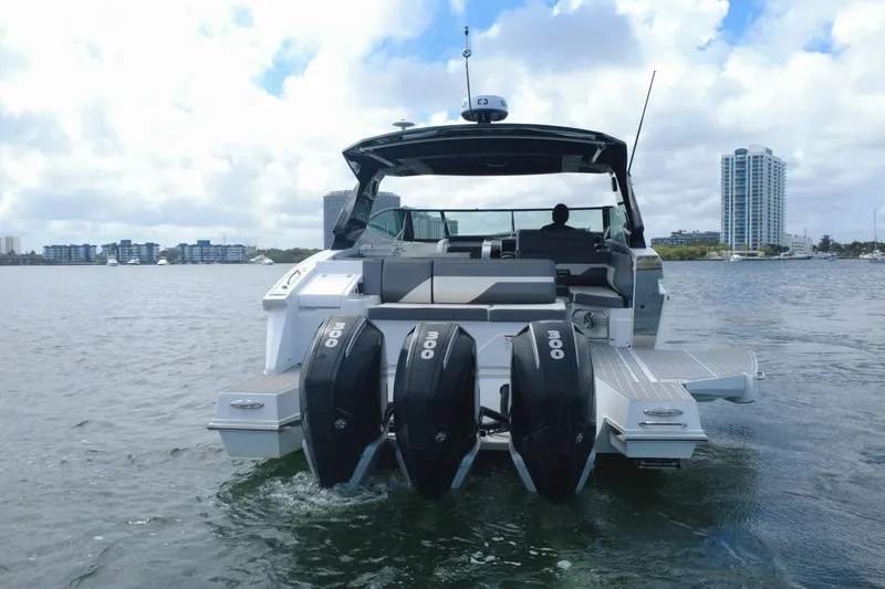 Slide: The Image of 2022 New Cruiser Yachts GLS 38 with triple engines on water, city skyline in background. - 16