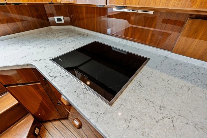 Slide: The Image of Modern kitchen in 2021 Viking 52 Sport Tower with sleek cooktop and marble countertop. - 52