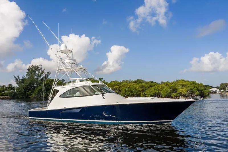 Slide: The Image of 2021 Viking 52 Sport Tower yacht cruising on a sunny day with blue skies. - 15