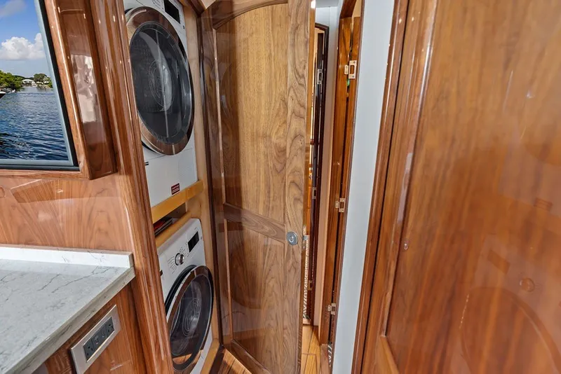 Slide: The Image of Interior of 2021 Viking 52 Sport Tower with wood paneling and laundry appliances. - 63