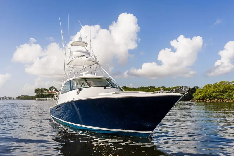 Slide: The Image of 2021 Viking 52 Sport Tower yacht on calm water under blue sky. - 21