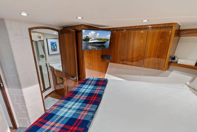 Slide: The Image of Luxurious interior of 2021 Viking 52 Sport Tower yacht with wood cabinetry and cozy bedding. - 56