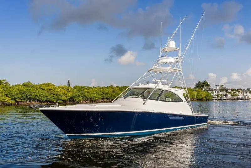 Slide: The Image of 2021 Viking 52 Sport Tower yacht cruising on a scenic waterway. - 7