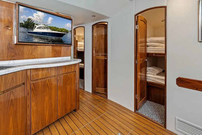Slide: The Image of Luxurious interior of 2021 Viking 52 Sport Tower with wood finishes and bunk beds. - 54