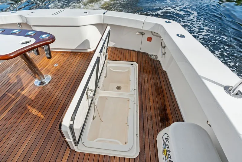 Slide: The Image of 2021 Viking 52 Sport Tower boat deck with open storage compartments and wooden flooring. - 31